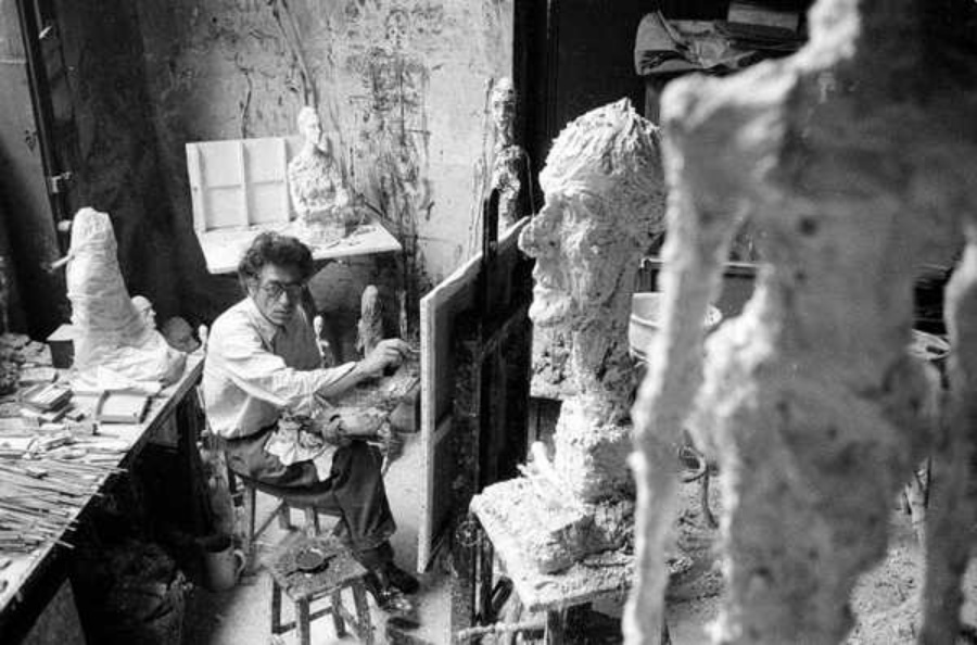A photo of Giacometti painting in his studio.