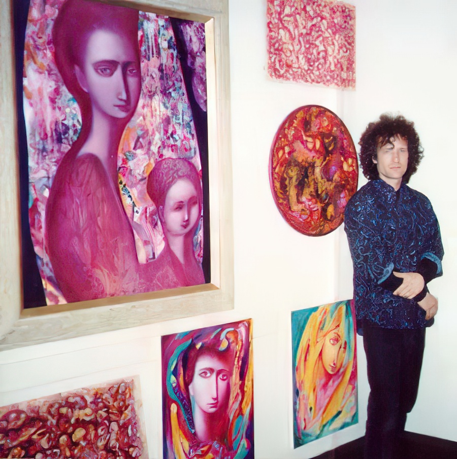 A photo of me standing by my oil paintings on a wall.