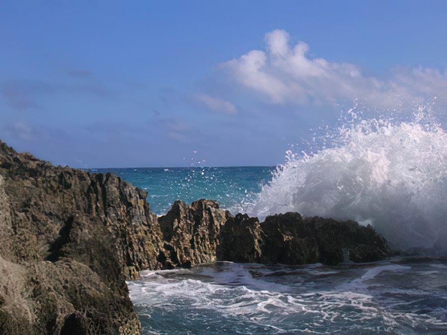 Waves crashing on rocks and blue water.