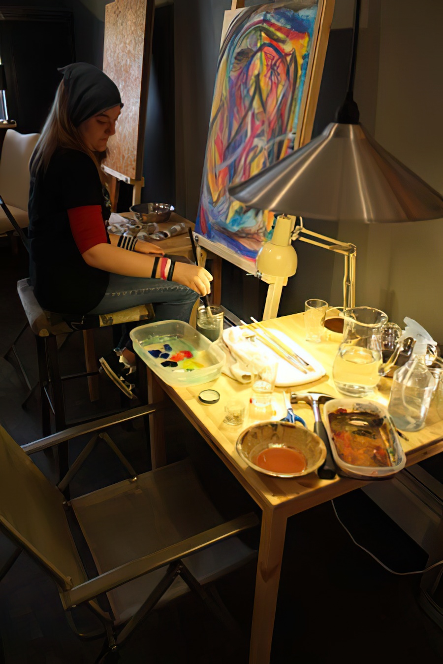 A student painting at the easel.