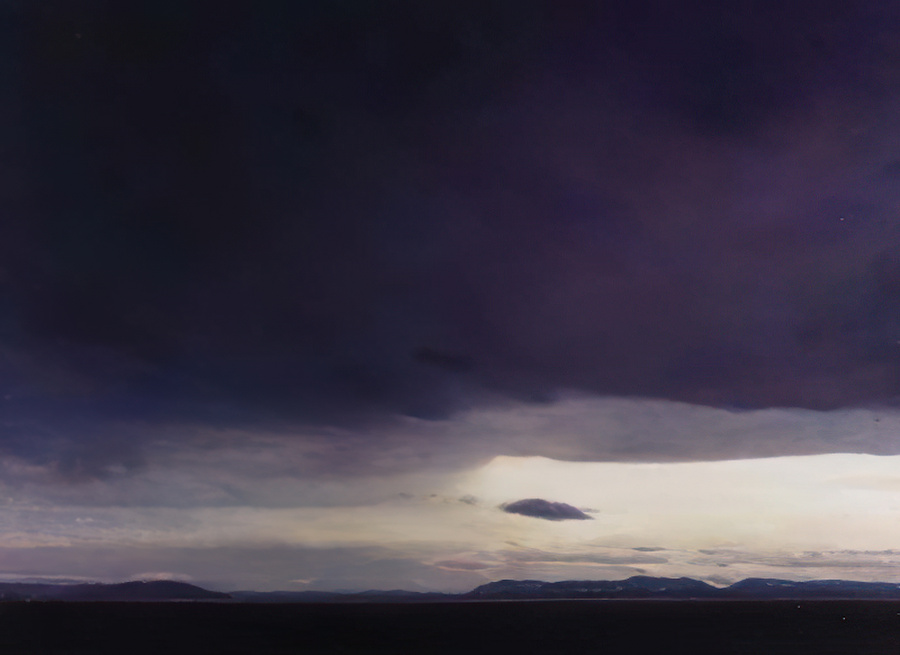 An oil painting of a break in the clouds over the Salis Sea.